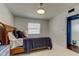 Bedroom with a woven bed frame, white walls, and lots of natural light at 1115 Rue Des Chateaux # 2B, South Pasadena, FL 33707