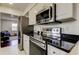 Well-equipped kitchen featuring stainless steel appliances and black granite countertops at 1115 Rue Des Chateaux # 2B, South Pasadena, FL 33707