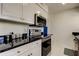 Bright kitchen offers stainless steel appliances, black countertops and white cabinetry at 1115 Rue Des Chateaux # 2B, South Pasadena, FL 33707