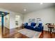 Well-lit living room with wood floors, blue sofa and stylish decor with three pictures at 1115 Rue Des Chateaux # 2B, South Pasadena, FL 33707