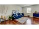 Well-lit living room with wood floors, a comfortable blue sofa, and stylish nautical decor with sailboat and oars at 1115 Rue Des Chateaux # 2B, South Pasadena, FL 33707