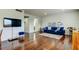 Bright living room with wood floors, a comfortable blue sofa, and stylish decor with TV at 1115 Rue Des Chateaux # 2B, South Pasadena, FL 33707