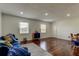 Cozy, bright living room with wood floors, two windows, and nautical-inspired decor with blue couch at 1115 Rue Des Chateaux # 2B, South Pasadena, FL 33707