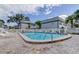 Community pool surrounded by lounge chairs and the community buildings at 1115 Rue Des Chateaux # 2B, South Pasadena, FL 33707