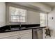 Light-filled bar area with stainless steel sink, dishwasher, and backyard views at 1115 Rue Des Chateaux # 2B, South Pasadena, FL 33707