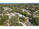 Expansive aerial view of a residential neighborhood with lush greenery and distant waterfront views at 1152 Jackmar Rd, Dunedin, FL 34698