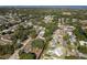 Wide aerial shot of homes in a tree-filled neighborhood, some with pools, extending to a waterway at 1152 Jackmar Rd, Dunedin, FL 34698