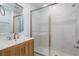 Bathroom with wood vanity, white marble-look shower, updated fixtures and vanity at 1152 Jackmar Rd, Dunedin, FL 34698