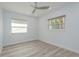 Bedroom featuring new floors, a ceiling fan and two windows for natural light at 1152 Jackmar Rd, Dunedin, FL 34698