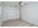 Bedroom with light grey wood floors, ceiling fan, and white trim at 1152 Jackmar Rd, Dunedin, FL 34698