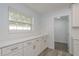 Bright kitchen with white cabinets, modern countertops, and lots of natural light from a large window at 1152 Jackmar Rd, Dunedin, FL 34698