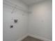 Simple laundry room with tile flooring, essential connections, and a wire shelf for storage at 1152 Jackmar Rd, Dunedin, FL 34698