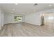 Bright and airy living room with light wood-look floors, a large window, and access to the modern kitchen at 1152 Jackmar Rd, Dunedin, FL 34698