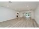 Open-concept living room with light wood-look floors and recessed lighting, connecting to the kitchen and outdoor pool area at 1152 Jackmar Rd, Dunedin, FL 34698