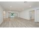 Spacious living room featuring wood-look floors, recessed lighting, and access to a bathroom, enhancing the modern appeal at 1152 Jackmar Rd, Dunedin, FL 34698