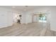 Open living area showcasing wood-look floors, seamless flow to the kitchen, and sliding doors to the outdoor pool at 1152 Jackmar Rd, Dunedin, FL 34698