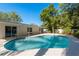 Backyard pool and patio area with a privacy fence and mature trees at 1152 Jackmar Rd, Dunedin, FL 34698