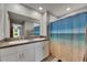 Bathroom featuring double sinks with granite countertops, a large mirror, and an ocean-themed shower curtain at 11707 Sunburst Marble Rd, Riverview, FL 33579