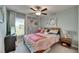 A bright bedroom with ceiling fan, stylish wall decor, and natural light at 11707 Sunburst Marble Rd, Riverview, FL 33579