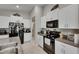 Modern kitchen with black appliances, granite countertops, and white cabinets for storage at 11707 Sunburst Marble Rd, Riverview, FL 33579