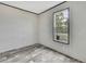 Bedroom showing a well-lit window and wood-look floors at 16137 Melbourne St, Brooksville, FL 34604