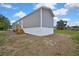 Exterior view of gray house with white trim and wooden steps to the front door at 16137 Melbourne St, Brooksville, FL 34604