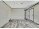 Spacious living room featuring wood look flooring and white walls with a large door leading into the next room at 16137 Melbourne St, Brooksville, FL 34604