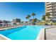 Inviting outdoor pool area offers ample seating, palm trees, and skyline views for relaxing poolside at 1621 Gulf Blvd # 1604, Clearwater Beach, FL 33767