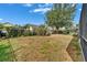 Spacious backyard with verdant grass, surrounded by a classic black metal fence and lush trees providing privacy at 16516 Bridgewalk Dr, Lithia, FL 33547