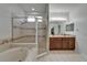 Bathroom with a soaking tub, glass-enclosed shower, and double vanity at 16516 Bridgewalk Dr, Lithia, FL 33547