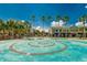 Community center with spiral water feature, manicured lawns, and palm trees on a clear, sunny day at 16516 Bridgewalk Dr, Lithia, FL 33547