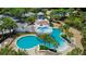 Gorgeous aerial view of turquoise pools and grotto with beautiful landscaping and mature palm trees at 16516 Bridgewalk Dr, Lithia, FL 33547