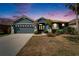Charming single-story home with a well-maintained lawn, palm trees, and two-car garage at 16516 Bridgewalk Dr, Lithia, FL 33547