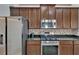 Well-equipped kitchen with stainless steel appliances, granite countertops, and dark wood cabinets at 16516 Bridgewalk Dr, Lithia, FL 33547