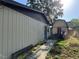A backyard view shows siding on a home with a detached garage with a red door at 1703 N Taylor Rd, Brandon, FL 33510