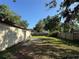 Backyard showcasing a partial concrete patio and well-maintained lawn with a wood fence at 1703 N Taylor Rd, Brandon, FL 33510