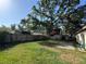 View of the backyard that contains a detached garage, well-maintained lawn and wood fence at 1703 N Taylor Rd, Brandon, FL 33510