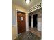 Inviting entryway featuring a dark wood front door, stone flooring, and decorative latticework above the hallway entrance at 1703 N Taylor Rd, Brandon, FL 33510