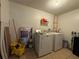 Functional laundry room with washer, dryer, storage shelves, and cleaning supplies; practical and organized at 1703 N Taylor Rd, Brandon, FL 33510