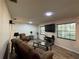 Comfortable living room featuring a sectional sofa, a flat-screen TV, and bright natural light through the windows at 1703 N Taylor Rd, Brandon, FL 33510