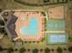Aerial view of community pool, playground, basketball and tennis courts with surrounding residential area at 19047 Alfaro Loop, Spring Hill, FL 34610