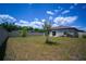 Expansive backyard with a young tree, fenced perimeter, and a small patio area at 19047 Alfaro Loop, Spring Hill, FL 34610