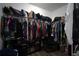 Walk-in closet with wood floors, rack shelving, hanging clothes, and organized shoes and bags at 19047 Alfaro Loop, Spring Hill, FL 34610