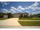 Beautifully landscaped single-story home with an attached garage and lush green lawn at 19047 Alfaro Loop, Spring Hill, FL 34610