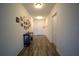 Long hallway with wood flooring, multiple doors, and decorative wall art at 19047 Alfaro Loop, Spring Hill, FL 34610
