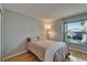 An airy bedroom features neutral walls, hardwood floors, and a large window allowing for natural light at 1910 Elk Spring Dr, Brandon, FL 33511