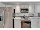 Stainless steel appliances and white cabinets, illuminated by recessed lighting, create a modern kitchen aesthetic at 1910 Elk Spring Dr, Brandon, FL 33511
