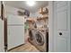Convenient laundry room with modern front-load machines, shelving, and ample storage space for laundry needs at 1910 Elk Spring Dr, Brandon, FL 33511