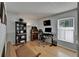 A bright home office space with hardwood floors, a desk, shelving, and a comfortable sitting area at 1910 Elk Spring Dr, Brandon, FL 33511