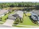 Aerial view of home with a lush lawn, landscaping, pond, and three-car garage at 19837 Lonesome Pine Dr, Land O Lakes, FL 34638